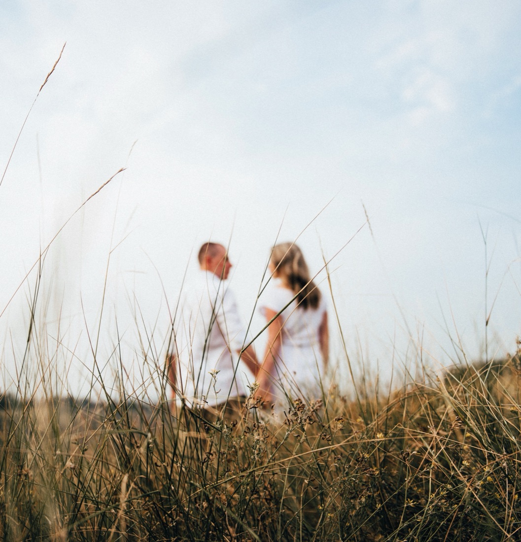 A couple standing together in a grassy field